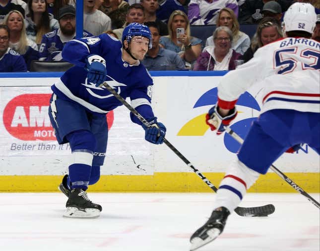 Mar 18, 2023; Tampa, FL, USA; Tampa Bay Lightning left wing Tanner Jeannot (84) passes the puck to the Montreal Canadiens during the first quarter at Amalie Arena Linebacker Justin Barron (52) defends.